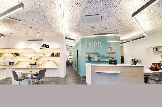 Modernes, helles Büro mit Empfangstresen, Regalen und stilvoller Inneneinrichtung.