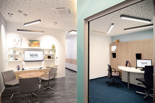 Modernes Büro mit Besprechungstisch, ergonomischen Stühlen und Computerarbeitsplätzen.